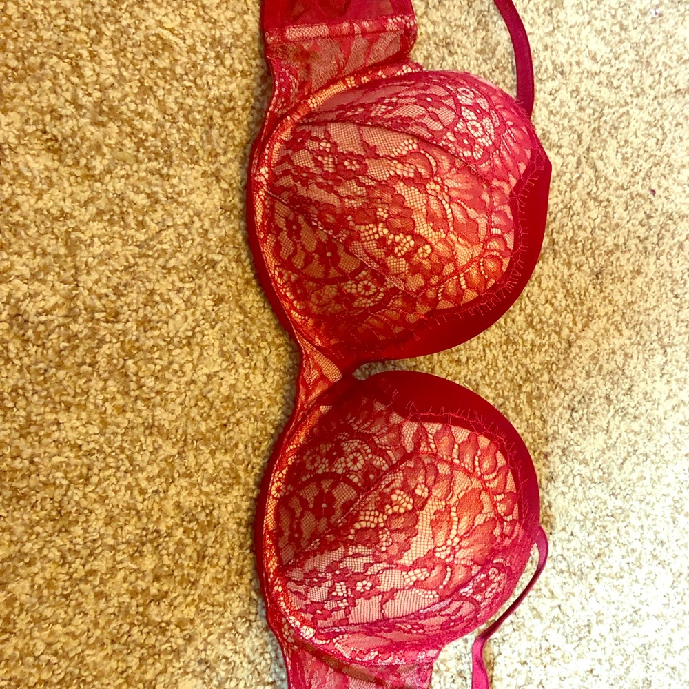 A lovely red and cream bra with lace detail .